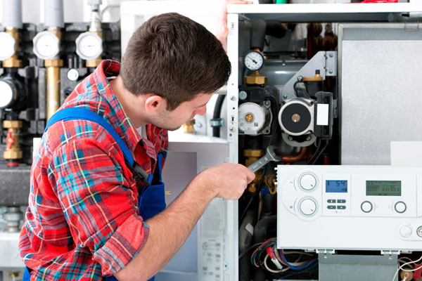 Heating technician repairing boiler controls in San Lorenzo