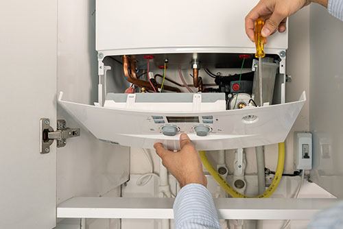 Heating technician repairing a residential boiler in San Lorenzo