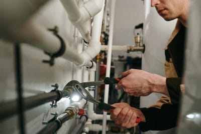 Technician inspecting commercial plumbing pipes in San Lorenzo