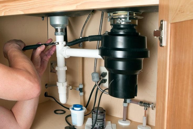 Plumber repairing a garbage disposal in San Lorenzo