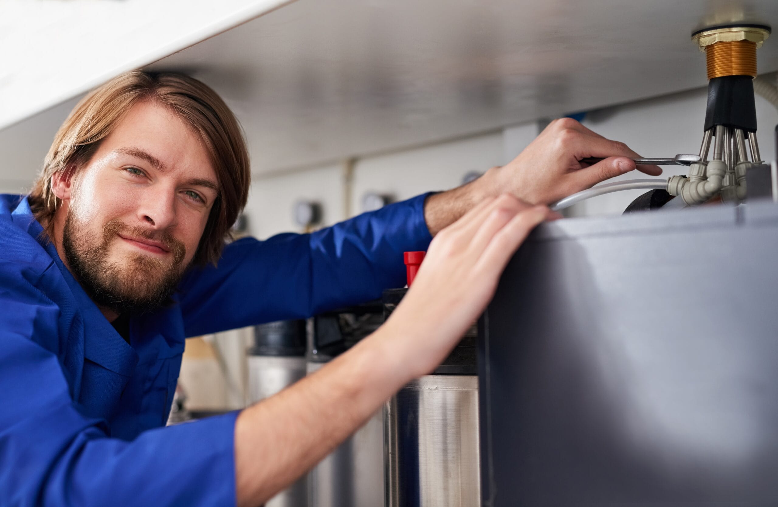 Technician servicing a residential water heater tank in San Lorenzo